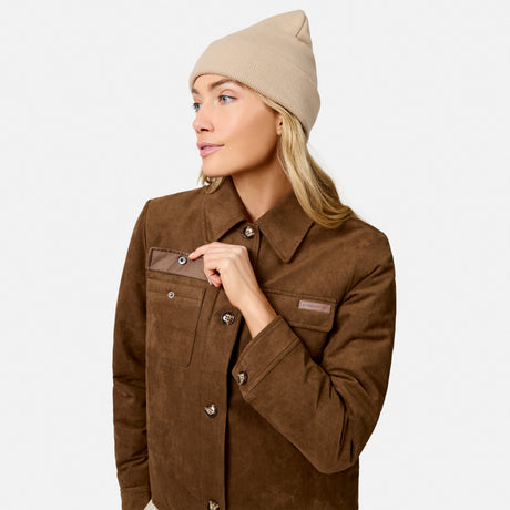 [Model is wearing size S.] A woman wearing a brown corduroy utility jacket and a beige knit beanie, photographed against a clean light gray studio background.