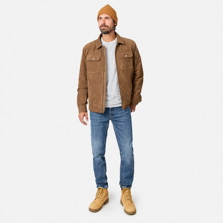 [Model is wearing size M.] A man wearing a brown suede jacket, blue jeans, tan boots, and a mustard yellow beanie, standing against a light gray studio background.