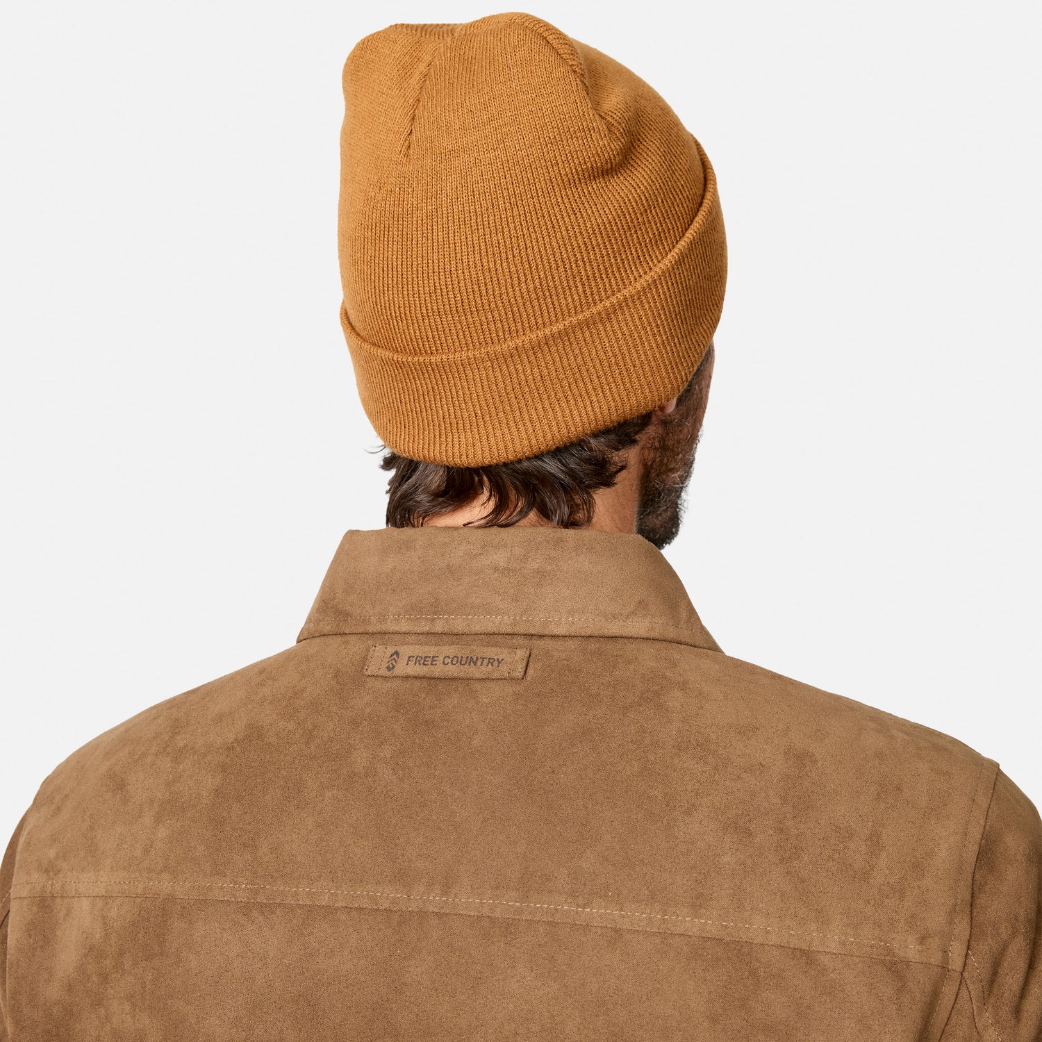 [Model is wearing size M.] Back view of a man wearing a ribbed mustard yellow beanie and a brown suede-like collared shirt jacket with a 'FREE COUNTRY' label on the collar, against a light gray background.