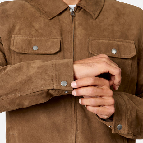 [Model is wearing size M.] Close-up of a person wearing a brown suede-like zip-front jacket with two flap chest pockets and buttoned cuffs, showing the hands adjusting the cuff.