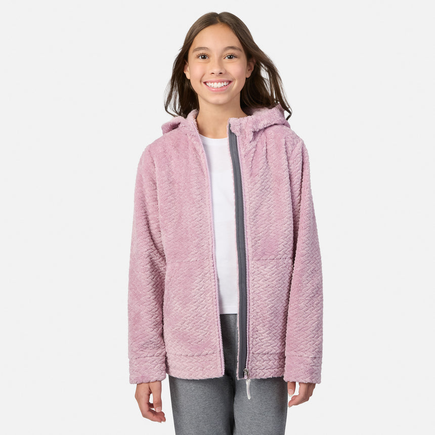 A girl wearing a pink Girls’ Braided Butter Pile® Jacket with a hooded design and a gray zipper over a white shirt.