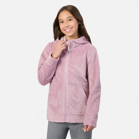 A smiling girl wearing a rosebud Girls’ Braided Butter Pile® Jacket, featuring a super soft, textured braided pattern and a zip-up hood.