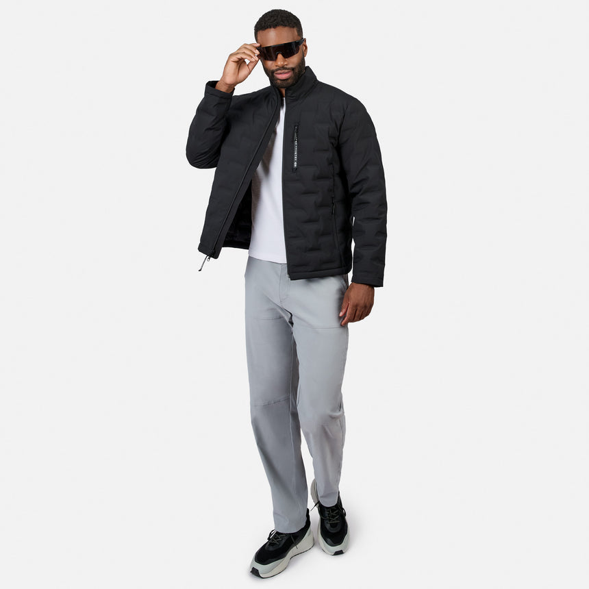 [Model is wearing size M.] A man modeling a black puffer jacket over a white t-shirt, paired with light gray sweatpants and black sneakers, against a plain light gray background.