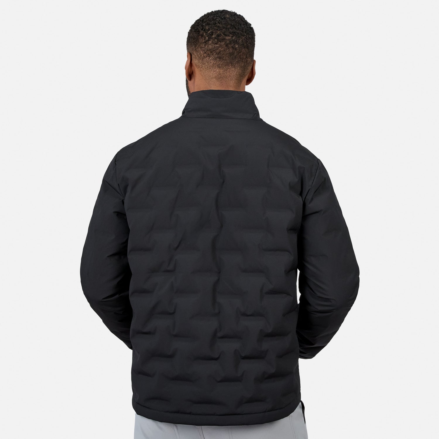 [Model is wearing size M.] A man viewed from the back wearing a black quilted puffer jacket with a stand-up collar, set against a plain light gray studio background.
