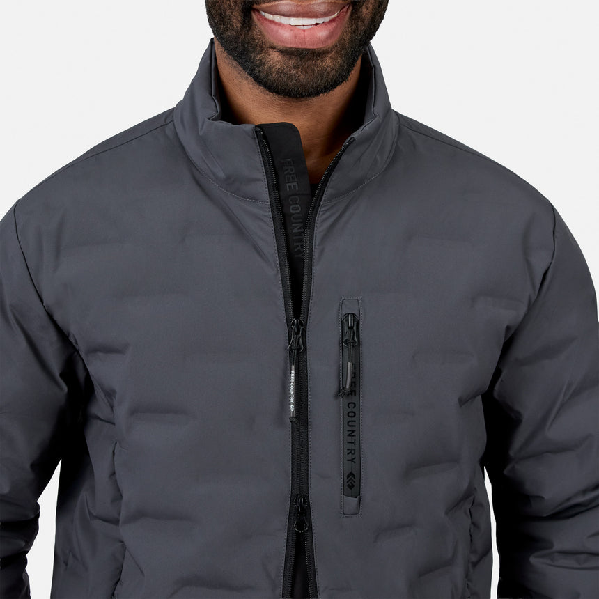 [Model is wearing size M.] A close-up of a man wearing a dark gray Country Life puffer jacket, showing the front zipper, stand-up collar, and a vertical zippered pocket on the chest.