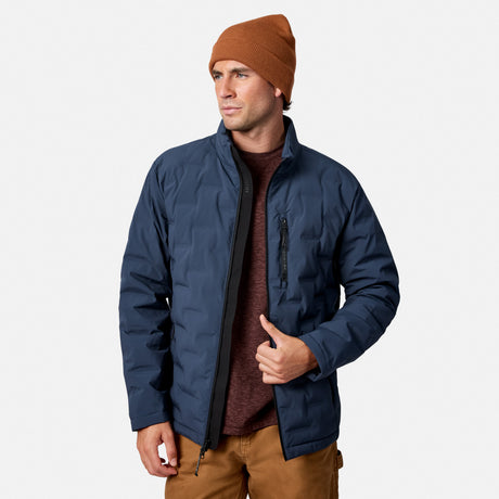 [Model is wearing size M.] A man wearing a navy blue quilted jacket, a brown knit beanie, and a maroon sweater, standing against a light gray studio background.