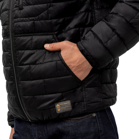 A person wearing the Clearance Men's FreeCycle® Brick Puffer+ Jacket in black, featuring a small rectangular label near the pocket, with one hand in the pocket, paired with dark blue jeans.
