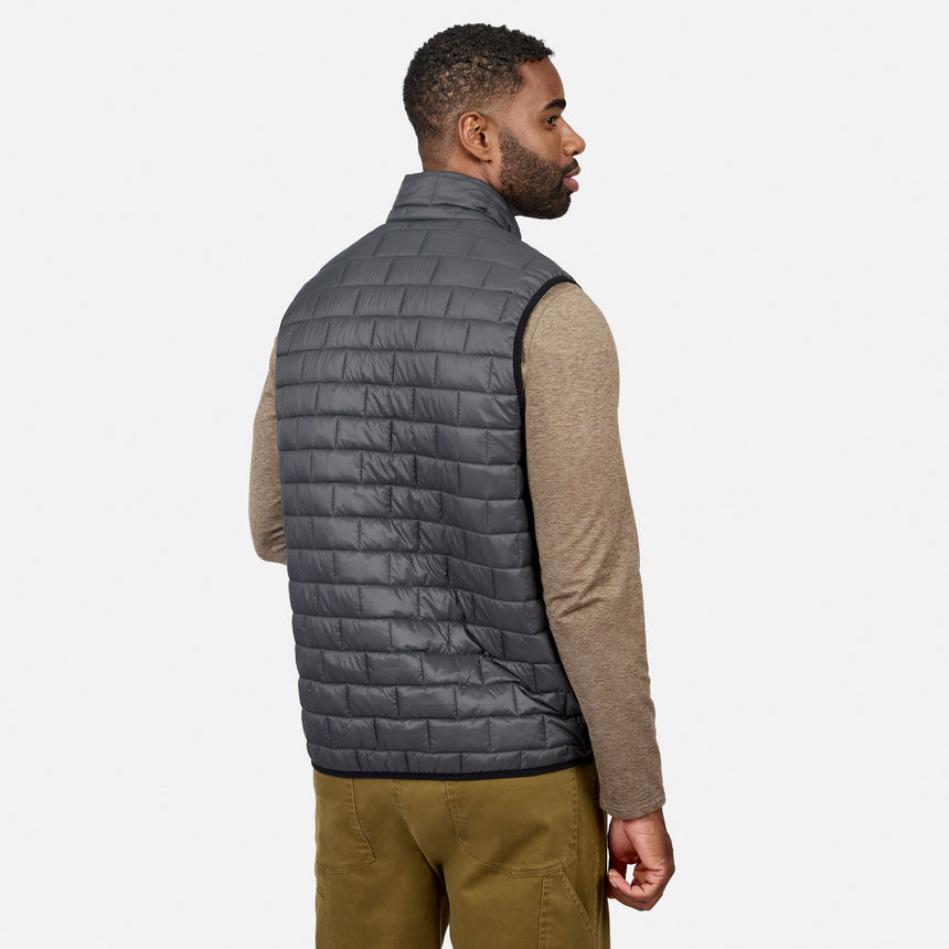 [Model is wearing size M.] A man shown from the back wearing a dark gray quilted puffer vest over a beige long-sleeve shirt and olive pants, against a light gray studio background.
