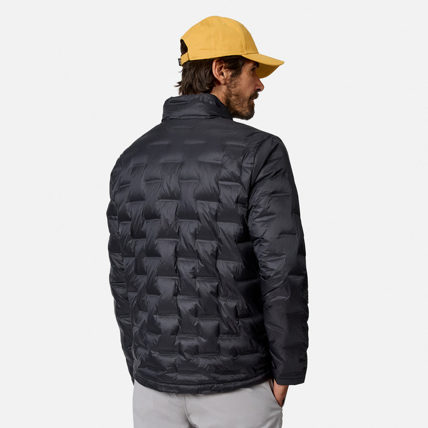 [Model is wearing size M.] A man wearing a black quilted puffer jacket, viewed from the back, paired with a yellow baseball cap and light gray pants, against a plain light gray background.