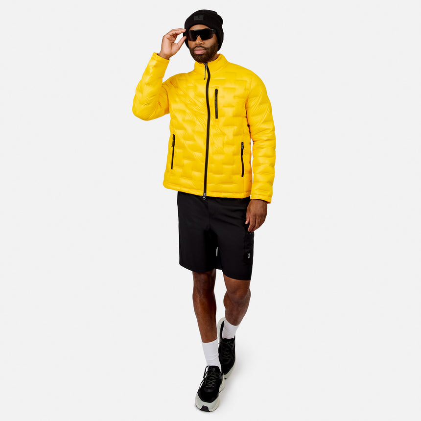 [Model is wearing size M.] A man modeling a bright yellow puffer jacket, black athletic shorts, black sneakers, white socks, and a black beanie against a light gray studio background.
