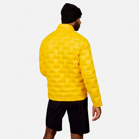 [Model is wearing size M.] A man wearing a bright yellow quilted puffer jacket, black beanie, and black shorts, shown from the back against a light gray studio background.