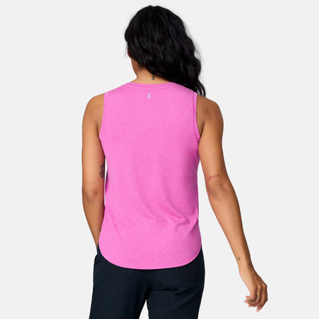 A person with long dark hair stands facing away, wearing the Clearance Women's Microtech® Chill B Cool Curved Hem Tank Top in bright pink and black pants, set against a light gray background.