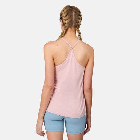 A woman with blonde braided hair stands with her back to the camera, wearing a light pink Free Country Women's Microtech® Chill B Cool V-Neck Cami Top with Built-In Bra and light blue shorts against a plain white background.