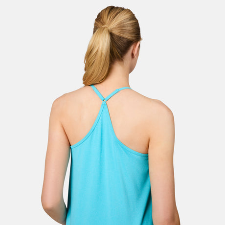 A woman with blonde hair in a low ponytail is shown from the back, wearing the Free Country Women's Microtech® Chill B Cool V-Neck Cami Top with Built-In Bra in light blue. The background is plain white.