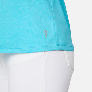 Close-up of a person wearing the Free Country Women's Microtech® Chill B Cool V-Neck Cami Top with Built-In Bra in light blue and white pants, showing the fabric texture and a small logo on the shirt’s hem from the waist down.