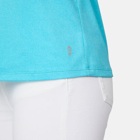 Close-up of a person wearing the Free Country Women's Microtech® Chill B Cool V-Neck Cami Top with Built-In Bra in light blue and white pants, showing the fabric texture and a small logo on the shirt’s hem from the waist down.