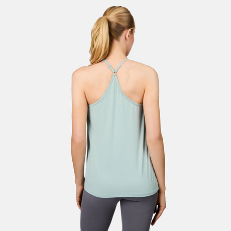 A blonde woman in a ponytail, seen from behind, models the Free Country Women's Microtech® Chill B Cool V-Neck Cami Top with Built-In Bra in light blue and gray leggings against a plain white background.