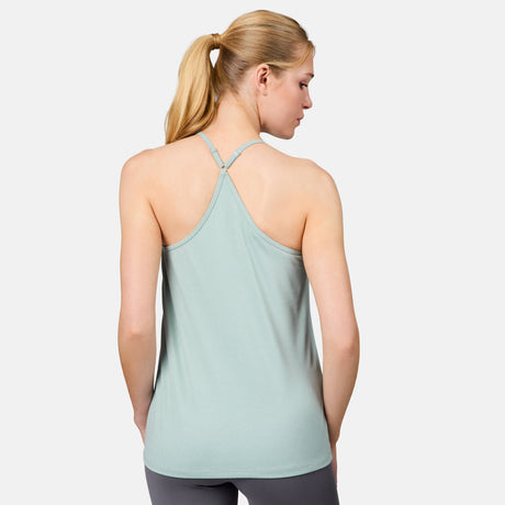 A woman with blonde hair in a ponytail is seen from the back, wearing the Free Country Women's Microtech® Chill B Cool V-Neck Cami Top with Built-In Bra in light green and gray leggings against a plain white background.
