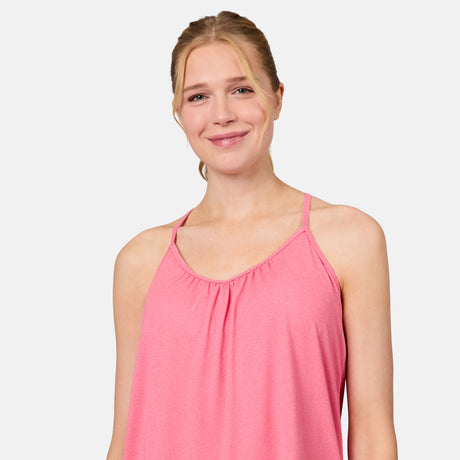 A blonde woman smiles, wearing the Free Country Women's Microtech® Chill B Cool V-Neck Cami Top with Built-In Bra in pink, standing against a plain white background.