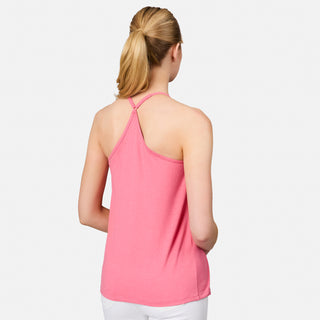 A woman with blonde hair in a ponytail is shown from the back wearing the Free Country Women's Microtech® Chill B Cool V-Neck Cami Top with Built-In Bra in pink, paired with white pants against a plain light background.