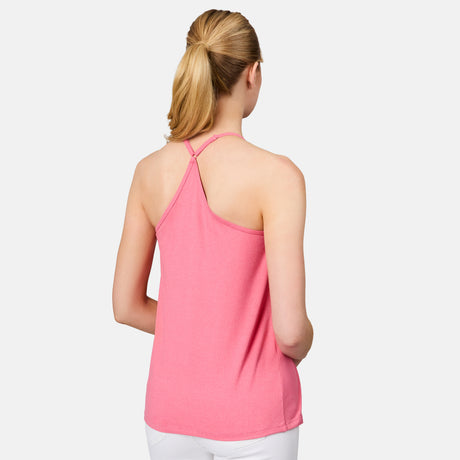 A woman with blonde hair in a ponytail is shown from the back wearing the Free Country Women's Microtech® Chill B Cool V-Neck Cami Top with Built-In Bra in pink, paired with white pants against a plain light background.