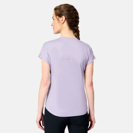 A woman with braided hair, seen from behind, wears the Free Country Women's Microtech® Chill B Cool Tee in light purple and black pants against a plain light gray background.