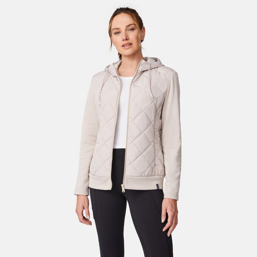 [Emily is 5'9" wearing size S.] Women’s light-colored quilted jacket with diamond-pattern stitching, zip-front closure, hood, and zippered pockets—layered over a white long-sleeve shirt and styled with black pants for a casual, cool-weather look.