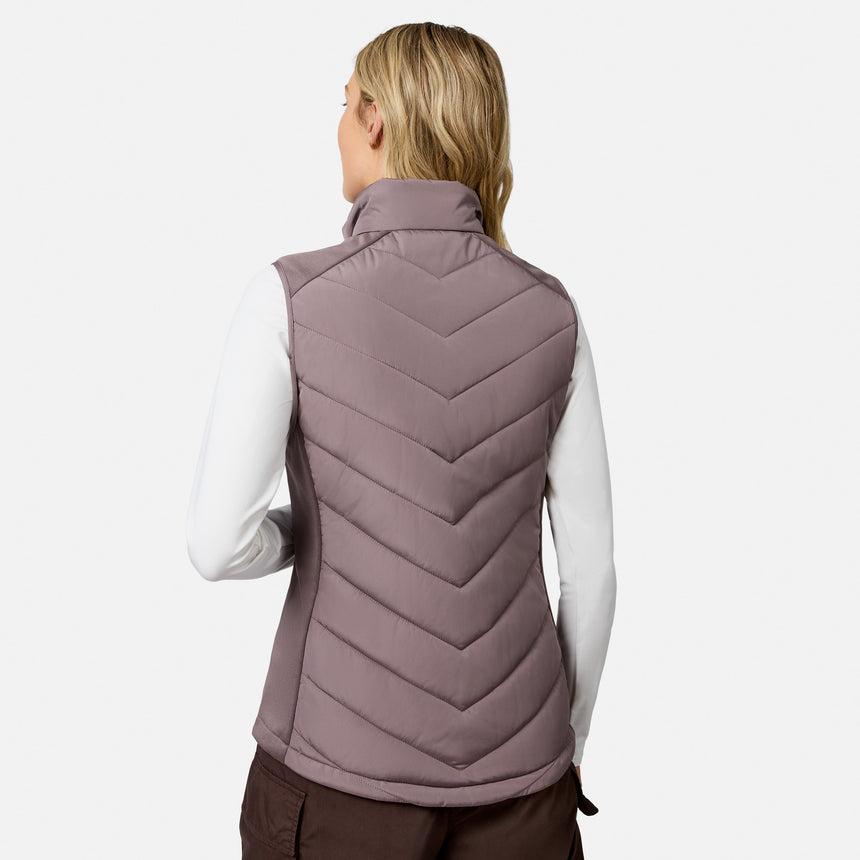 Back view of a person wearing a lightweight, mauve Women’s Quilted Hybrid Vest by Free Country over a long-sleeved white shirt.