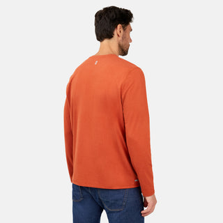 A man faces away from the camera, wearing the Free Country Men's FreeCycle® Sueded Melange Long Sleeve Crew Neck in orange with blue jeans, set against a plain white background.