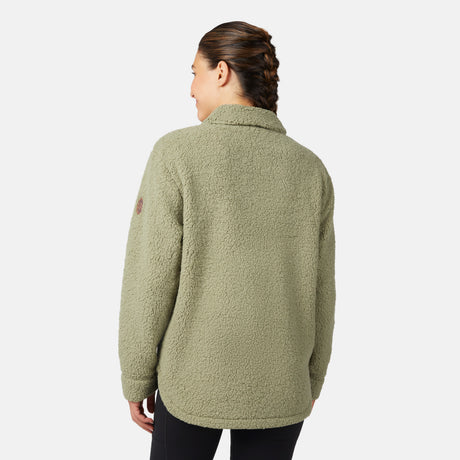 A woman with braided hair is seen from the back wearing the Women's Sherpa Shacket by Free Country in olive green, featuring an oversized fit with black pants, against a plain white background.