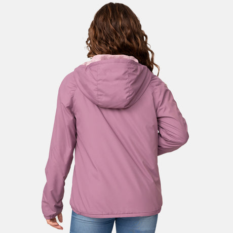 A person with wavy brown hair is shown from the back, wearing the Clearance Girls' Windshear Jacket in light purple and blue jeans against a plain white background.