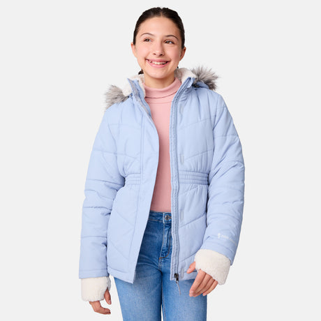 [Samantha is wearing size M] Model wearing a light blue Free Country winter jacket with faux fur-trimmed hood, quilted body, and white fleece-lined cuffs; styled with blue jeans for a casual, cold-weather look.