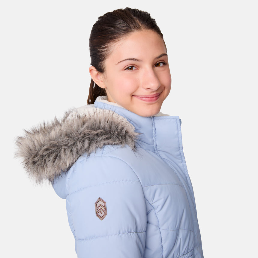 [Samantha is wearing size M] Model wearing a light blue Free Country winter jacket with faux fur-trimmed hood, quilted body, and white fleece-lined cuffs; styled with blue jeans for a casual, cold-weather look.