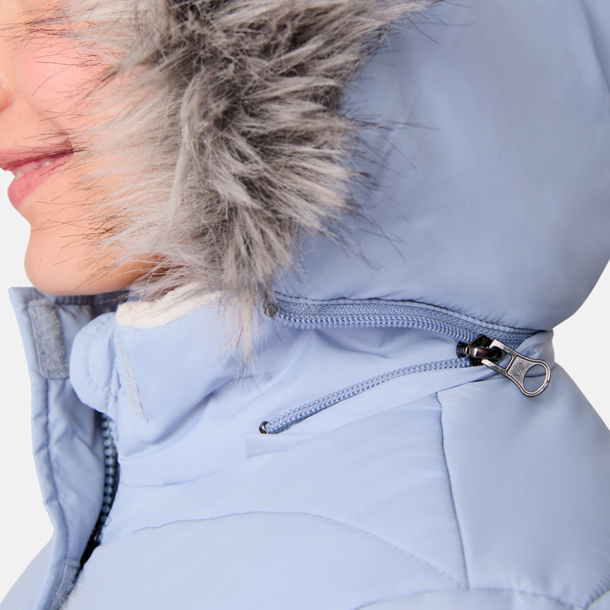 [Samantha is wearing size M] Model wearing a light blue Free Country winter jacket with faux fur-trimmed hood, quilted body, and white fleece-lined cuffs; styled with blue jeans for a casual, cold-weather look.