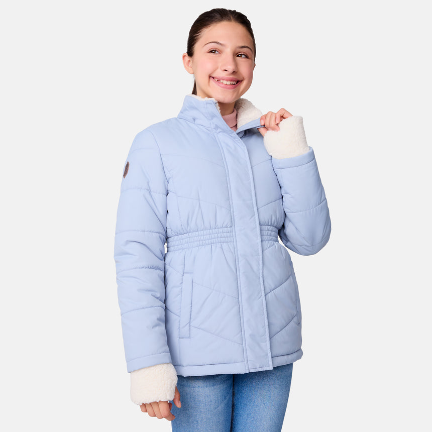 [Samantha is wearing size M] Model wearing a light blue Free Country winter jacket with faux fur-trimmed hood, quilted body, and white fleece-lined cuffs; styled with blue jeans for a casual, cold-weather look.