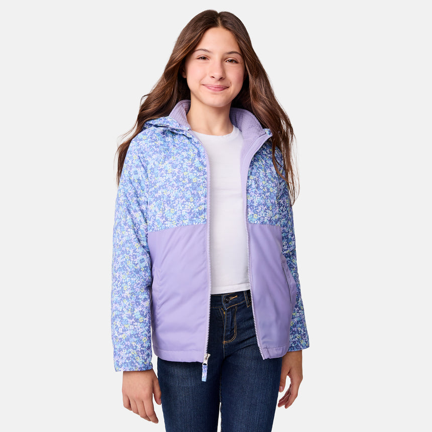 [Samantha is wearing size M.] Women's Free Country softshell jacket with floral upper print and solid lavender lower panels, featuring a zip-front closure and soft purple inner lining—designed for lightweight warmth and outdoor versatility.