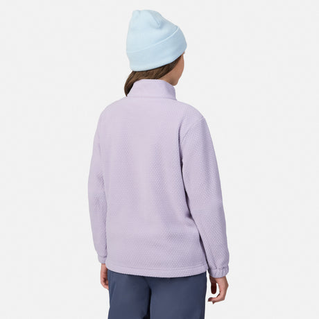 Back view of a girl wearing the Girls' 3-in-1 Systems Jacket in lavender with a light blue beanie and pink gloves