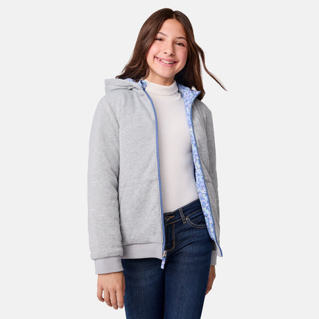 [Samantha is wearing size M.] Model wearing Free Country blue floral-patterned zip-front jacket with gray ribbed cuffs and hem—reverses to a solid gray hoodie for dual styling. Paired with a light gray turtleneck and dark blue jeans for a cozy-cool winter vibe.
