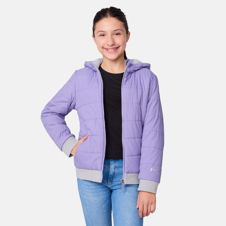 [Samantha is wearing size M.] Model wearing a Free Country light purple puffer jacket with zip-front closure, gray ribbed cuffs and hem, and matching hood—reverses to a casual gray hoodie for versatile styling, shown with relaxed blue jeans for a laid-back winter look.