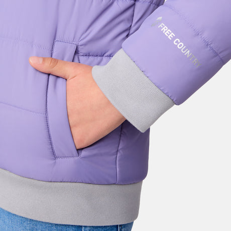 [Samantha is wearing size M.] Model wearing a Free Country light purple puffer jacket with zip-front closure, gray ribbed cuffs and hem, and matching hood—reverses to a casual gray hoodie for versatile styling, shown with relaxed blue jeans for a laid-back winter look.