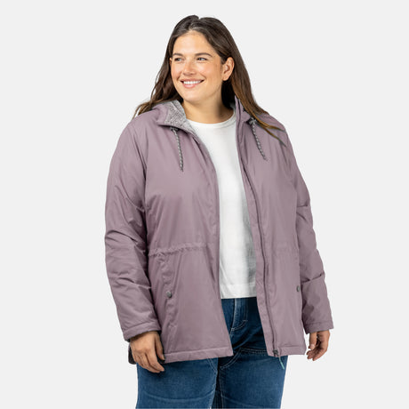 [Model is wearing a size 1X.] Woman wearing Free Country Women's Cascade Windshear Jacket in light purple with a full front zipper opening, soft lining, and water resistant and wind resistant recycled polyester stretch performance fabric, light grey background. Best women’s jacket for windy weather.