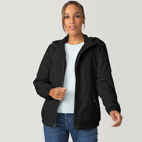 [Shelby is 5'9" wearing a size Small.] Woman wearing the Free Country Women's Breezy Bomber Windshear Jacket in black, featuring a hooded design and Iced Butter Pile® lining, standing casually with hands in pockets against a plain background.