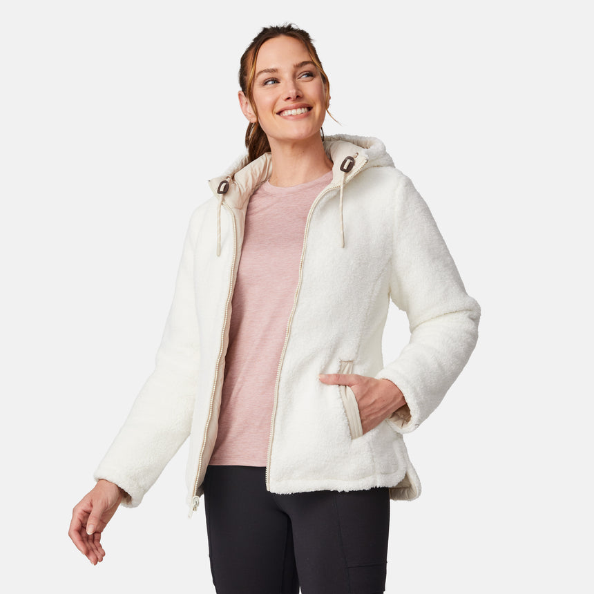 [Emily is 5'9" wearing size S.] Women’s Free Country cream-colored quilted hooded jacket with full-zip closure, drawstring hood, and dual hand pockets—reversible to cozy sherpa for versatile styling and added cold-weather comfort. Styled with jeans for a relaxed, outdoorsy look.