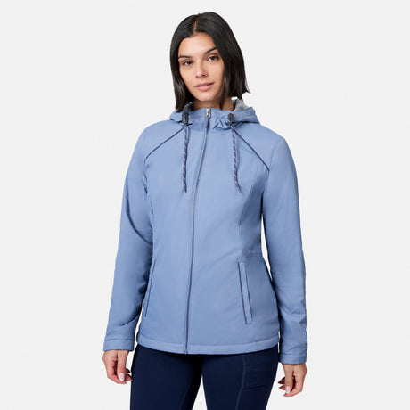 A woman wearing the Free Country Women’s Anorak Windshear Jacket in Dusk, featuring wind resistance and zipped pockets, stands facing the camera against a plain white background.