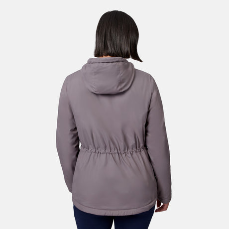 A woman wears the Free Country Women’s Anorak Windshear Jacket in light purple, shown from behind to highlight the drawstring waist and back details, standing against a plain white background.