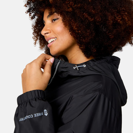 A woman with curly hair smiles and looks to the side while wearing the Women's Plus Size Outland Windshear Jacket from Clearance.