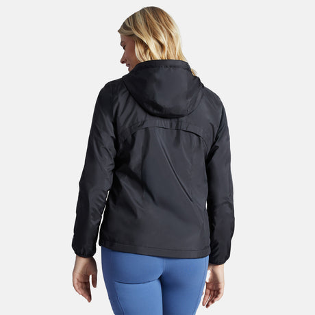 A blonde woman is shown from the back, looking over her shoulder while wearing the Clearance Women's Trek Mate Windshear Jacket in black and blue leggings against a plain white background.