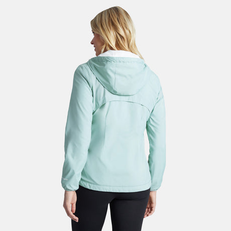 A woman with blonde hair, seen from behind, wears the Clearance Women's Trek Mate Windshear Jacket in light blue and black pants against a plain, light background.