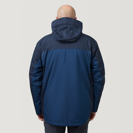 A bald person wearing a dark blue Men's FreeCycle® Jack Frost 3-in-1 Systems Jacket by Clearance, featuring a hood, is seen from behind against a plain light grey background.