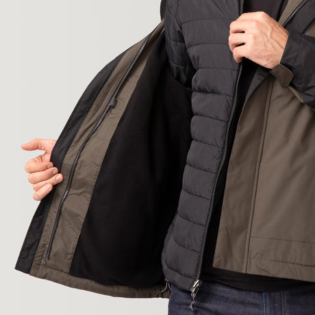A person displays the Men's FreeCycle® Jack Frost 3-in-1 Systems Jacket by Clearance in black and olive, revealing its black inner lining. The zip-closure jacket is shown without the person's head visible in the image.